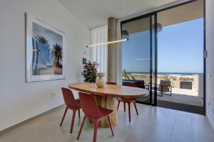 a dining room with a wooden table and chairs at Kokomo beachfront in Cotillo