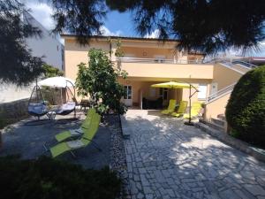 a patio with chairs and umbrellas in front of a building at Apartmani Lea in Jadranovo