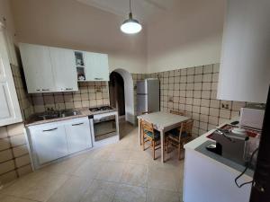 a kitchen with white cabinets and a table in it at Casa marina civico 3 in Pizzo