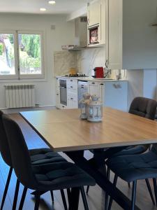 a kitchen with a wooden table and chairs at Maravilloso apartamento en Llívia in Llivia