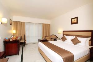 a hotel room with a bed and a desk at The Rialto Hotel in Bengaluru +35 photos