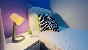 een slaapkamer met een bed met een lamp en kussens bij Solo Stay Partition Room in Al Barsha 1 in Dubai