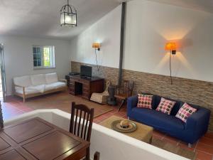 a living room with a blue couch and a table at Elegant Villa Mello with Beautiful Outdoor Area in Lourinhã