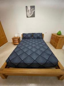 a bed with a blue comforter in a room at Westmorland in Busot +6 photos