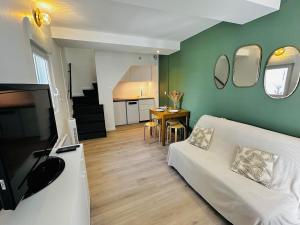 a living room with a white couch and a table at Maison de village - Centre Pérols, terrasse, wifi - Rue calme in Pérols