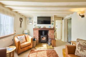un salon avec un canapé et une cheminée dans l'établissement Host & Stay - Pebble Cottage, à Corpusty