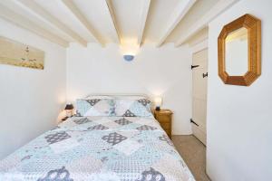 a bedroom with a bed and a mirror on the wall at Host & Stay - Pebble Cottage in Corpusty +12 photos