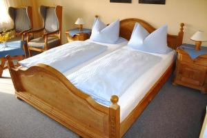 巴特法兴格Appartementhaus Mit Balkon Und Gemeinschaftsgarten的一张大木床，配有白色床单和枕头 更多5张照片