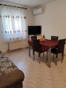 a dining room with a table and chairs and a television at Apartment Eni in Matulji
