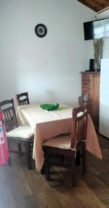 a table and chairs with a white table and a refrigerator at Adega do Xano in Cais do Galego