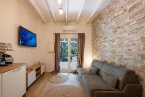 a living room with a couch and a brick wall at La ferme Saint-Antoine in Gassin