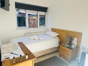 a bedroom with a bed with a desk and a window at ROYAL OAK in Kinnersley
