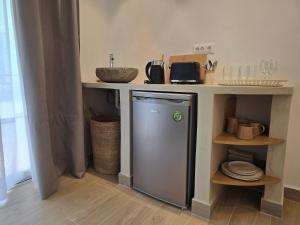 a kitchen with a small refrigerator under a counter at Pension Zoi in Kolymbia