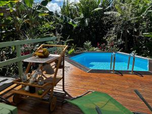 a swimming pool sitting next to a wooden deck at Magnifique gite in Lamentin