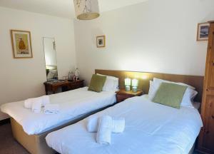 two twin beds in a room with two mirrors at ROYAL OAK in Kinnersley +6 photos