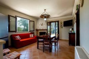 a living room with a red couch and a table at Villa Mira Exclusive with Pool- Noto Sicily in Noto Marina