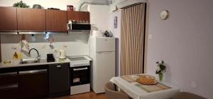a small kitchen with a white refrigerator and a table at Mike1890 in Portorož