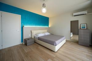 a bedroom with a bed and a blue wall at Italian Vacation Homes - Easy Living Iseo Lake in Predore