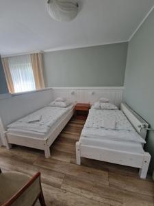 dwa łóżka w pokoju z oknem w obiekcie AGIS Pokoje Gościnne w Gdańsku