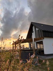 a house with a black roof on a field at Orawskie wzgórze in Jabłonka