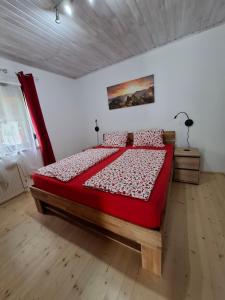 Ferienhaus Edelweiss في سانكت كانزيان: غرفة نوم بسرير كبير مع لحاف احمر