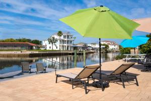 a group of chairs and an umbrella next to the water at Sunsets and Dolphins in Hernando Beach