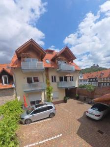 a house with two cars parked in front of it at Ferienwohnungen Burgfried in Wernigerode