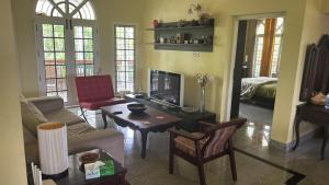 a living room with a couch and a tv at FOURWINDS Bungalow in Kozhikode