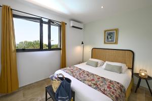 a bedroom with a large bed and a window at La Villa Plein Soleil in L'Isle-sur-la-Sorgue +19 photos