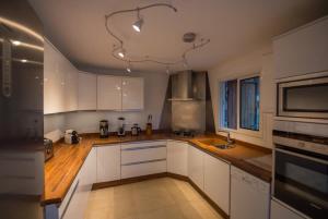 una cocina con armarios blancos y encimeras de madera en Modern Villa with Tropical Vibe in Grand Fond Hillside, en Grand Fond 12 fotos más