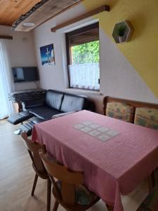 Ferienhaus Edelweiss في سانكت كانزيان: غرفة معيشة بها طاولة وأريكة