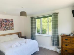 a bedroom with a white bed and a window at ROYAL OAK in Kinnersley