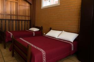 zwei Betten in einem Zimmer mit einer Ziegelwand in der Unterkunft Pousada Primavera in Cachoeira Paulista + 7 Fotos