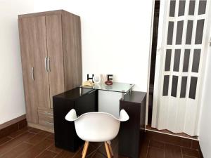 a desk and a white chair in a room at Hospedaje Pimentel in Pimentel