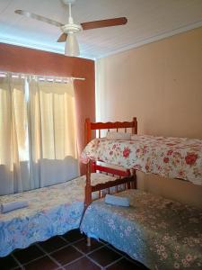 a room with two bunk beds and a ceiling fan at Apto Centro de Búzios - 2 Quartos - Ar-condicionado in Búzios