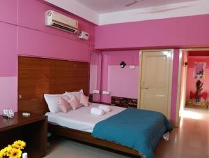 Jāmbにあるarushi home stayのピンクの壁のベッドルーム1室、ベッド1台が備わります。