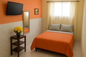 ein kleines Schlafzimmer mit einem Bett und einem Spiegel in der Unterkunft Pousada Primavera in Cachoeira Paulista