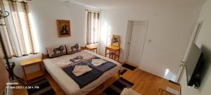 a bedroom with a bed and a television in it at Къща за гости Пъстрина in Sŭbotkovtsi