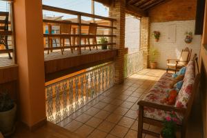 einen Balkon mit einem Sofa und einem Tisch in der Unterkunft Pousada Primavera in Cachoeira Paulista