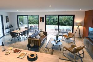 a living room with a couch and a table at La Villa Plein Soleil in L'Isle-sur-la-Sorgue