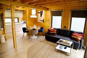 una sala de estar con un sofá y una mesa en Domki Na Lato, en Łukęcin 42 fotos más