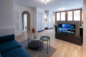 a living room with a blue couch and a tv at Italian Vacation Homes - Easy Living Iseo Lake in Predore