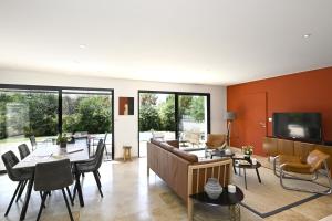 a living room with a couch and a table at La Villa Plein Soleil in L'Isle-sur-la-Sorgue
