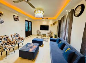 a living room with a blue couch and chairs at G-town living in Gurgaon