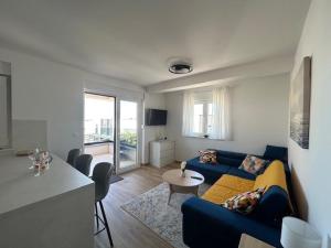 a living room with a blue couch and a table at Apartman Lejana in Mandre