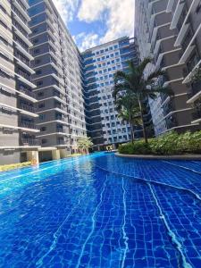 a swimming pool in front of some buildings at Mao condotel shore 3 residence in Manila