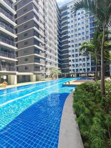 a swimming pool in front of some tall buildings at Mao condotel shore 3 residence in Manila
