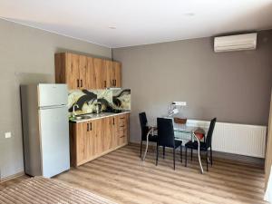eine Küche mit Kühlschrank und einem Tisch mit Stühlen in der Unterkunft Apartment Pompeus in Mzcheta