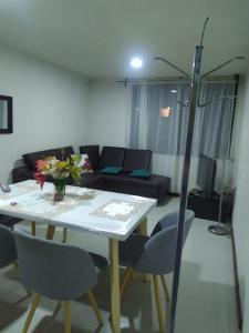 a living room with a table and chairs and a couch at Apartamento acogedor Duitama in Duitama
