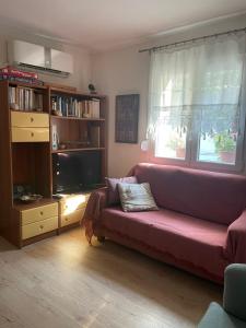 a living room with a couch and a tv at Mediterranean house in Skala Sotiros